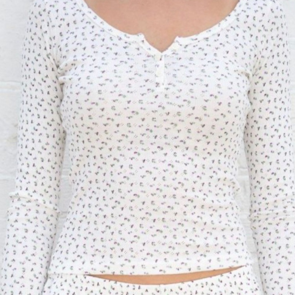 Brandy Melville Longsleeve Zelly Top in white with floral pattern.